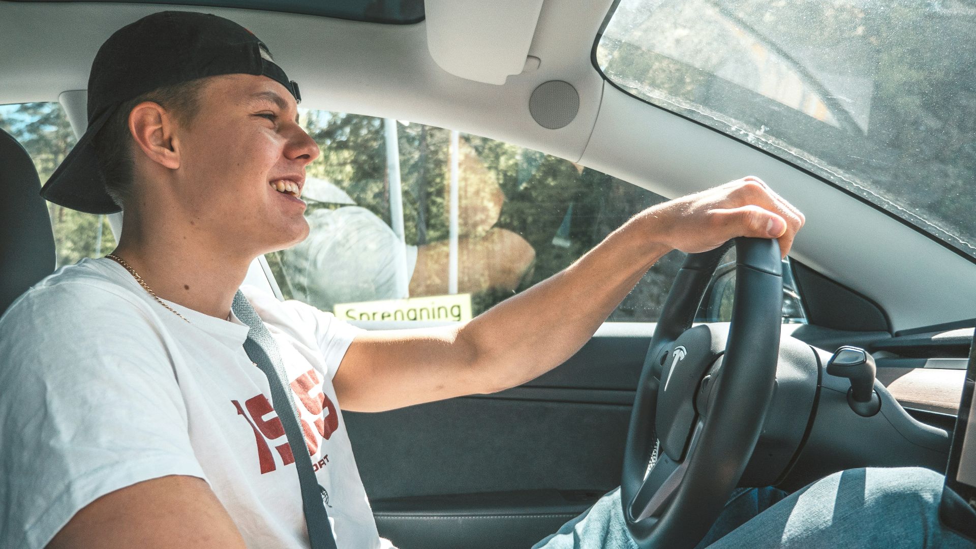 man in white crew neck t-shirt driving car