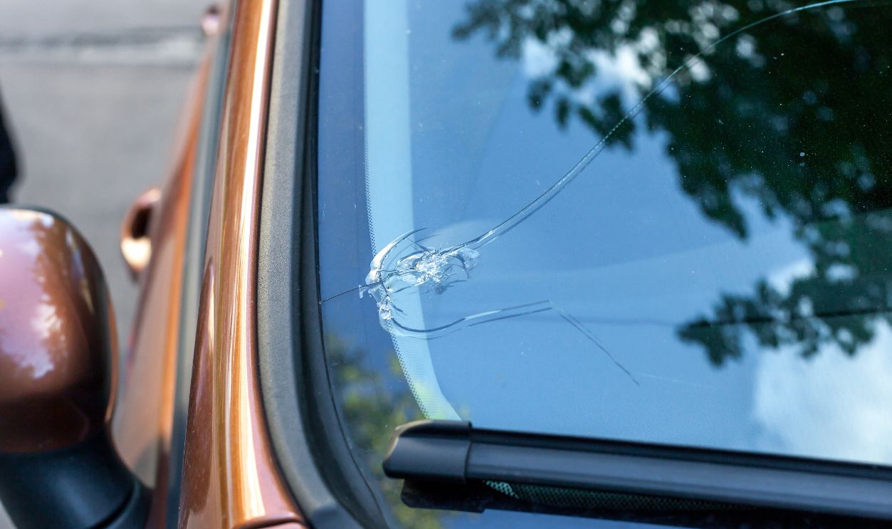 Broken car windshield glass from stone. Damaged windscreen on vehicle, close up