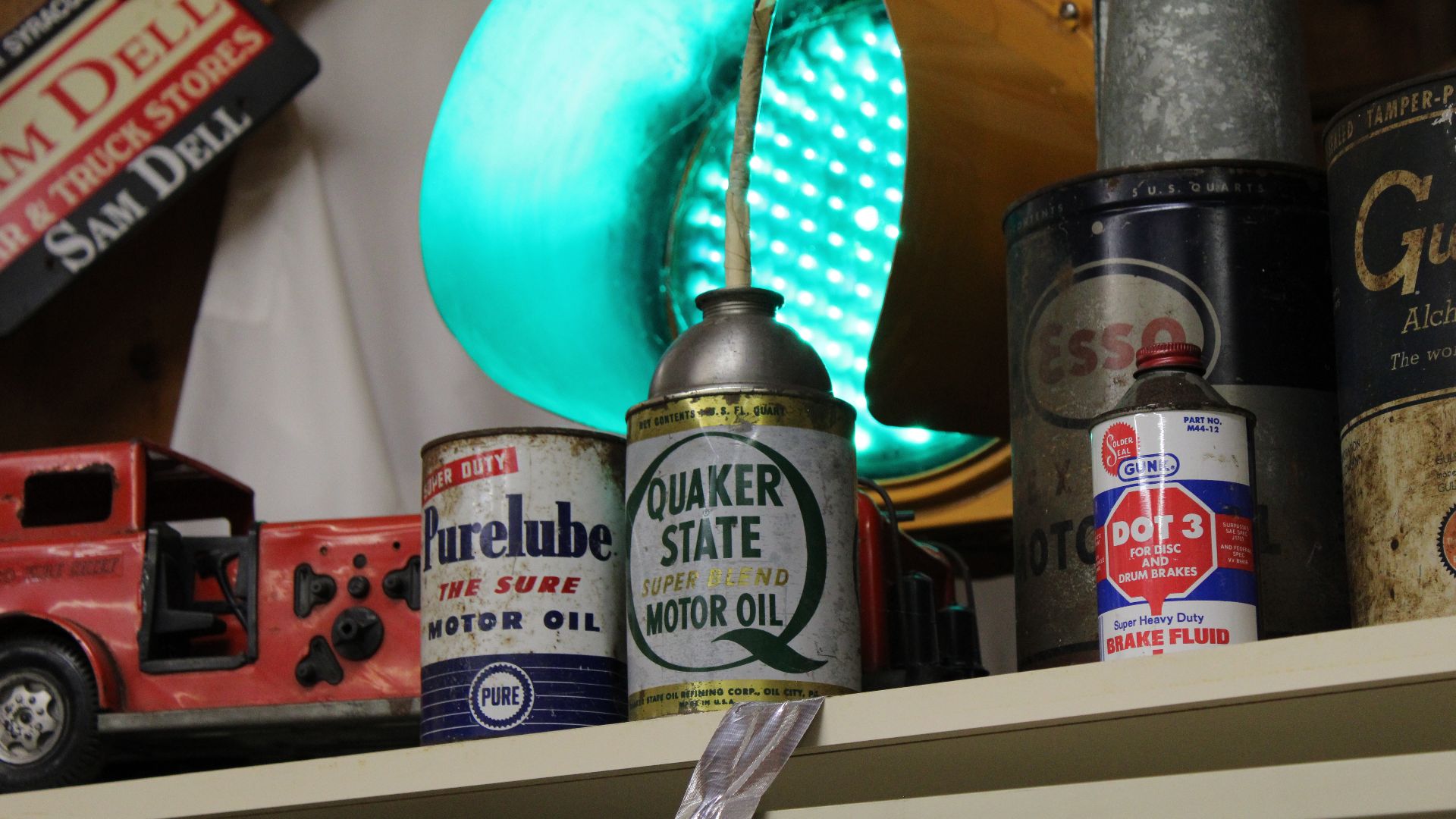 Cans of motor oil and brake fluid in front of the green lamp of a traffic light