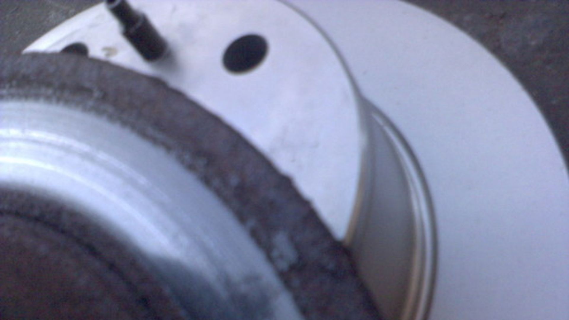 A pair of brake discs, one badly worn, one new