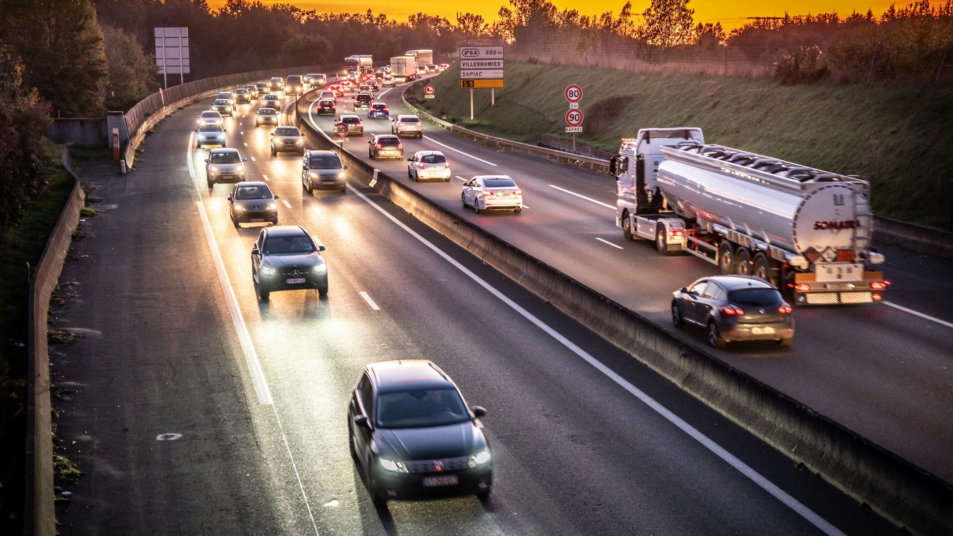 A highway filled with lots of traffic at sunset