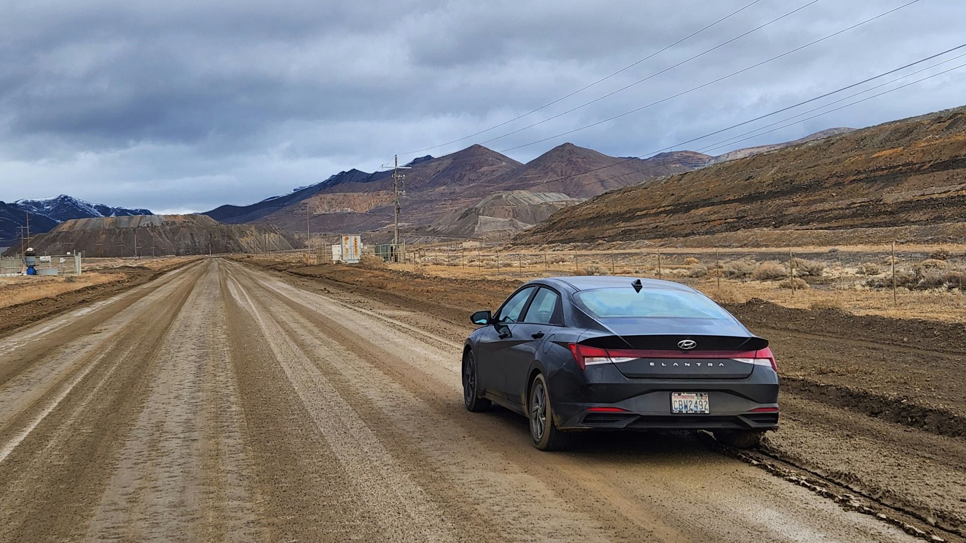 a car parked on a dirt road in the middle of nowhere