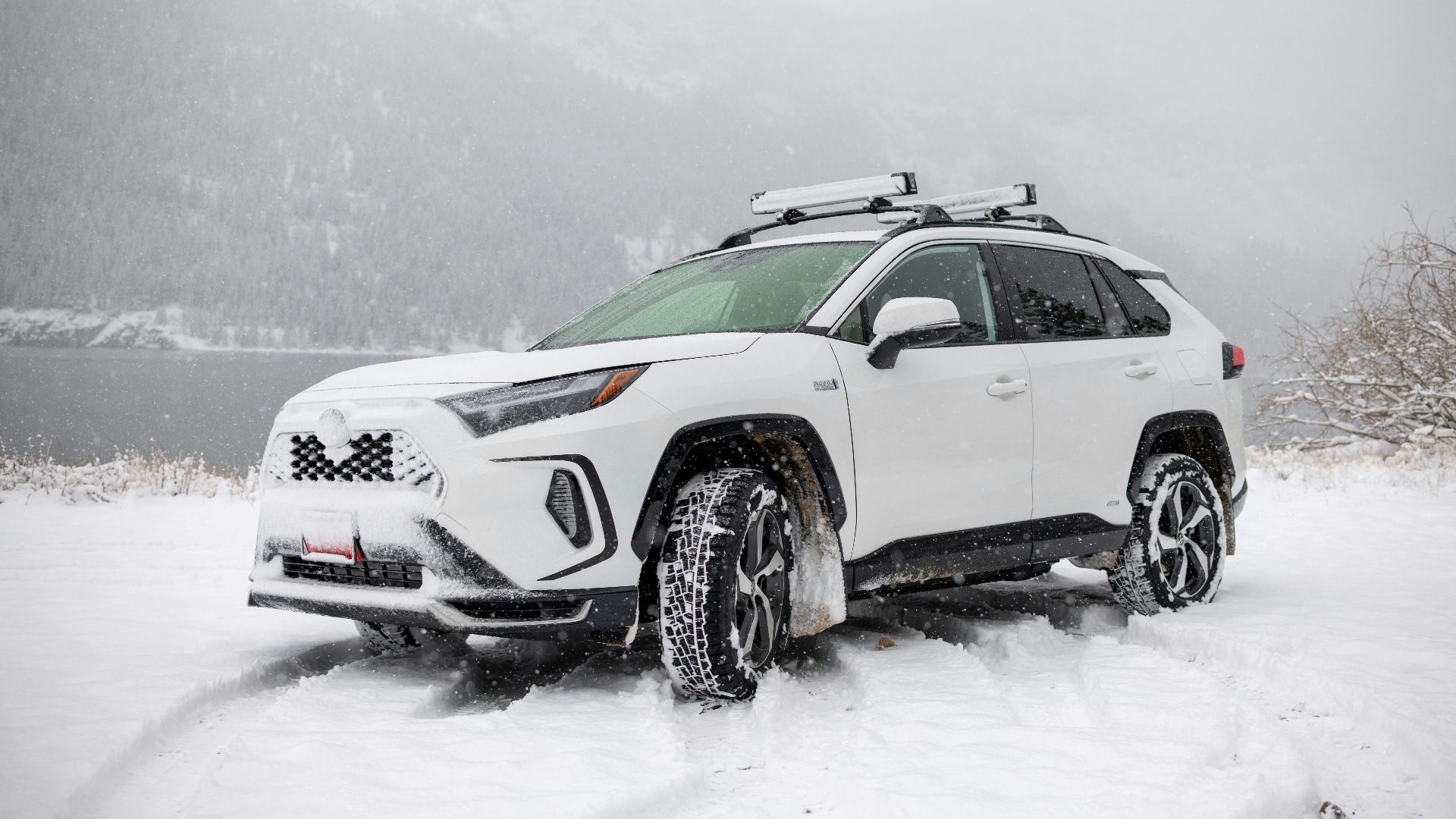 a white suv is parked in the snow
