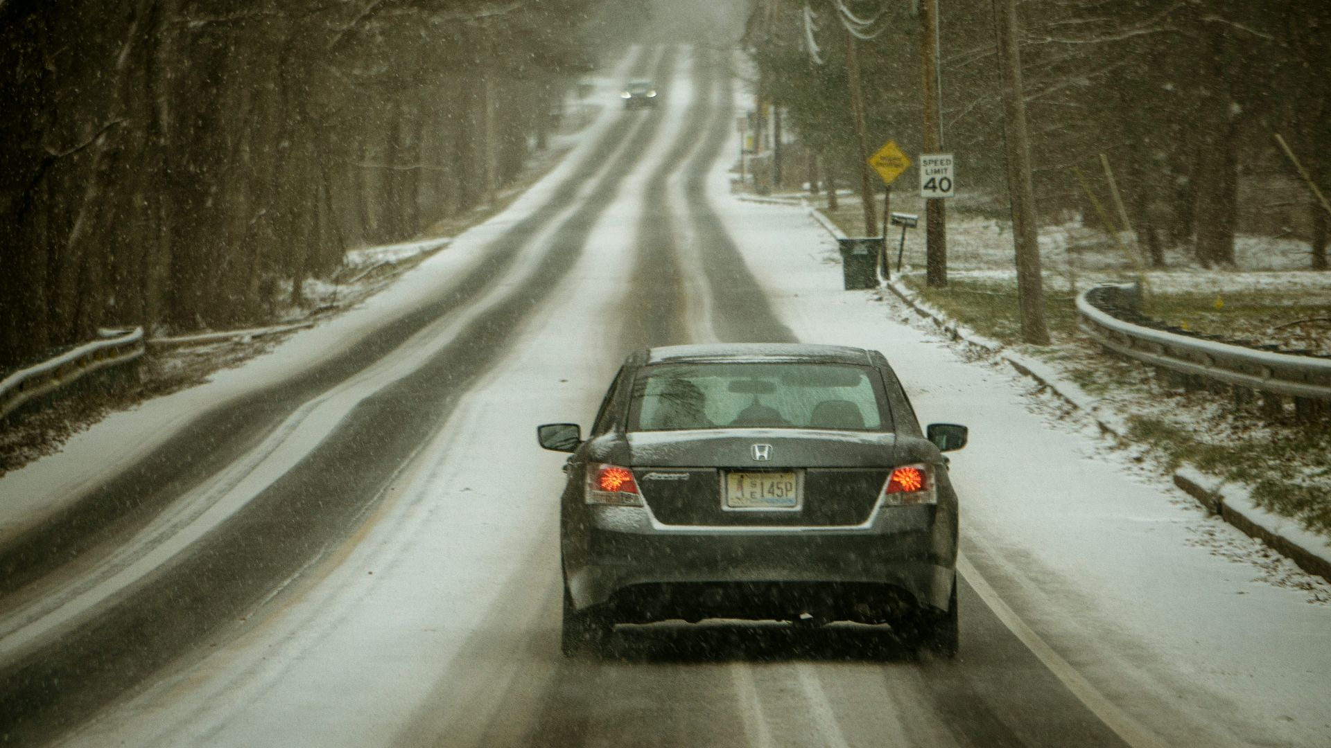black car on road covered with snow during daytime