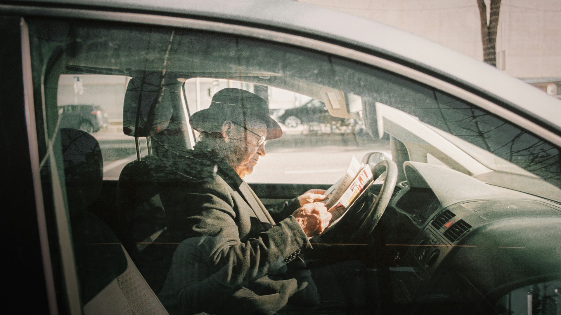 man in black jacket driving car