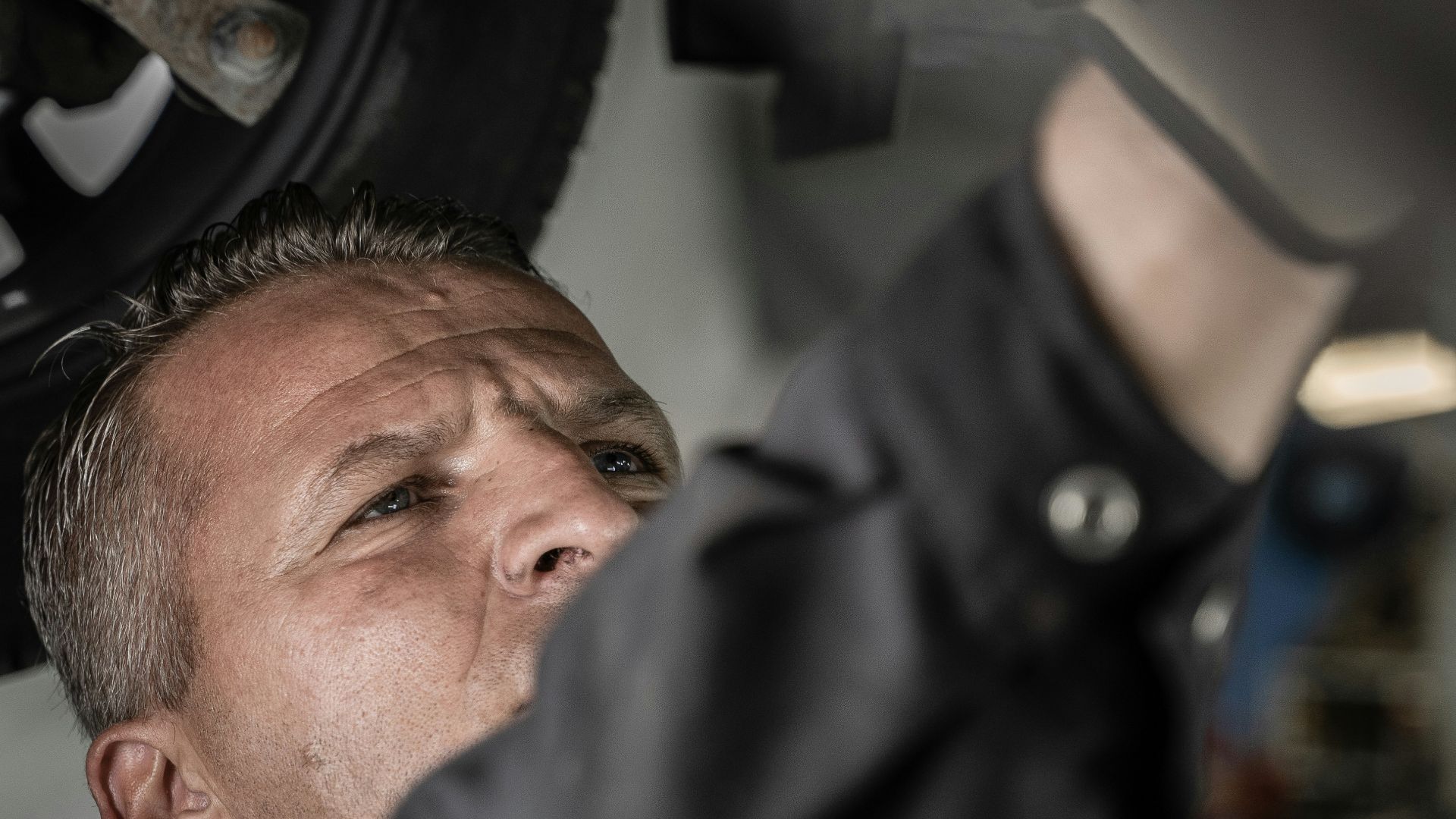 a man working on a car under a vehicle