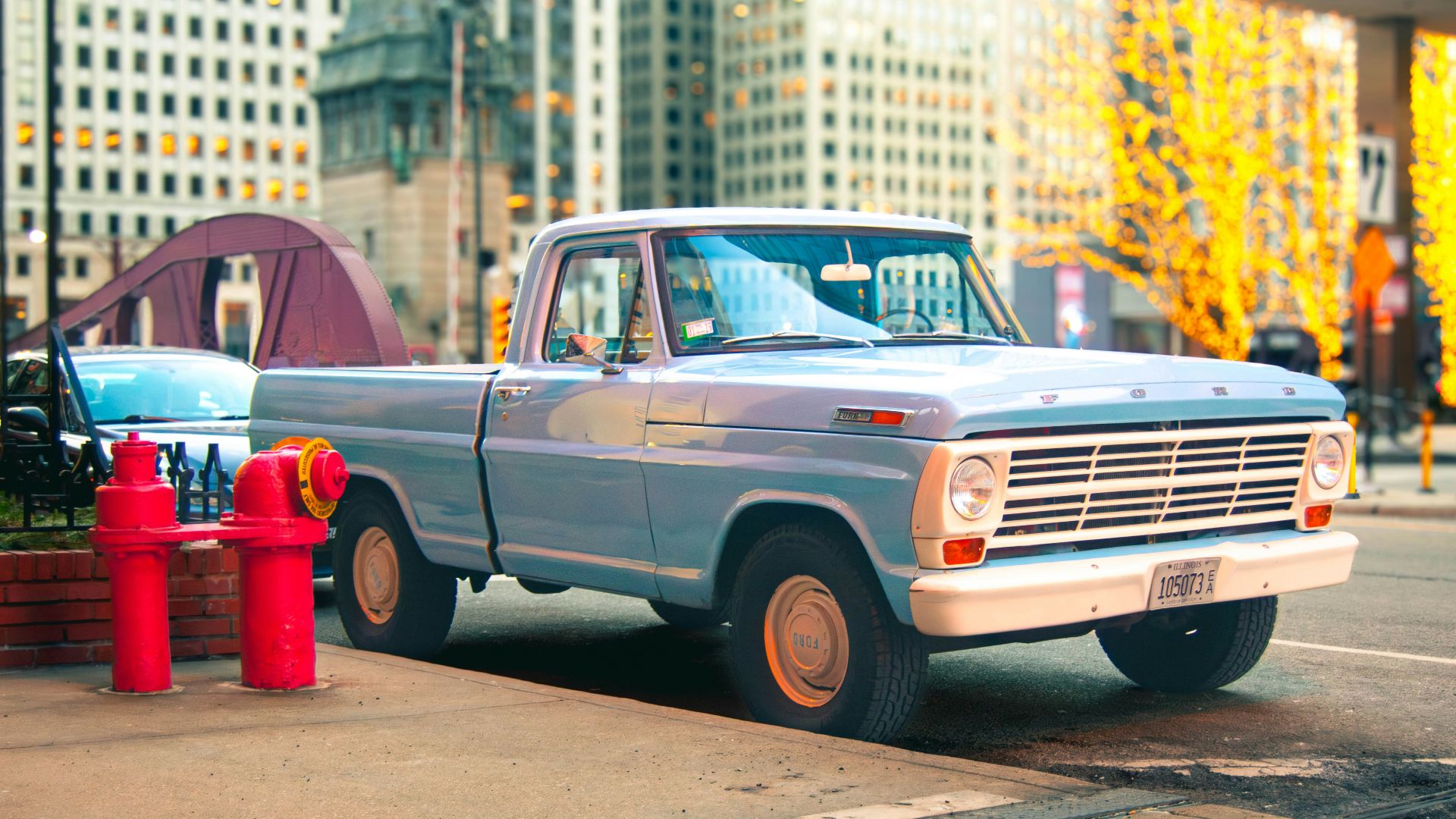 Light blue vintage pickup truck parked on city street