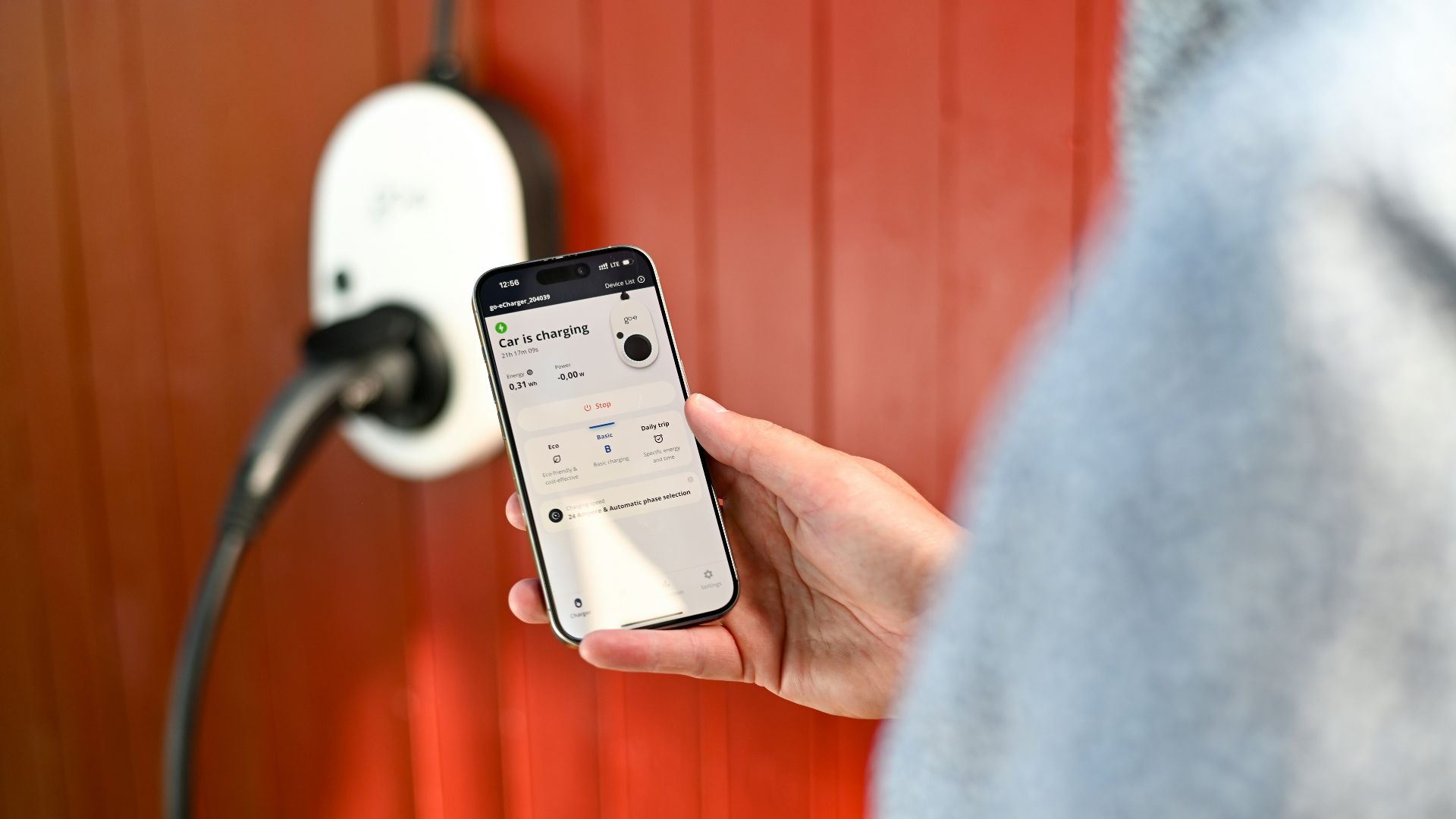 Person uses phone to control electric vehicle charger.