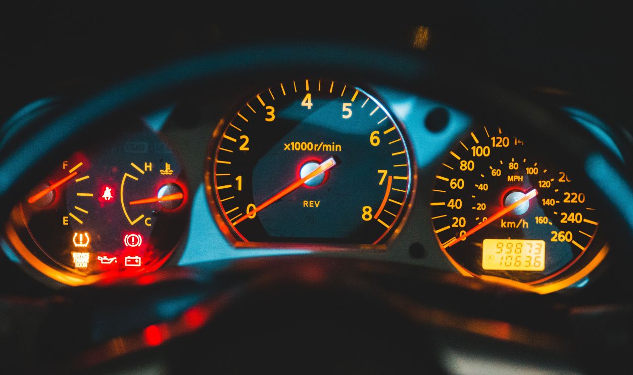Close-up view of a car dashboard featuring illuminated speedometer and tachometer