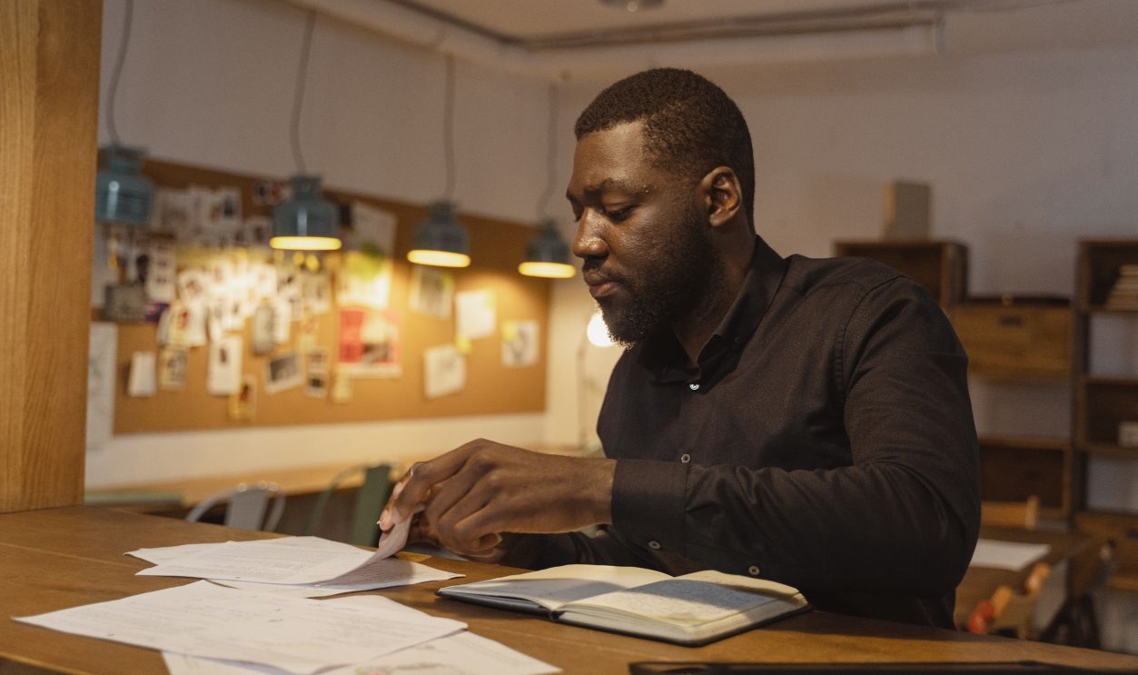 A businessman working diligently with documents in a cozy indoor office setting