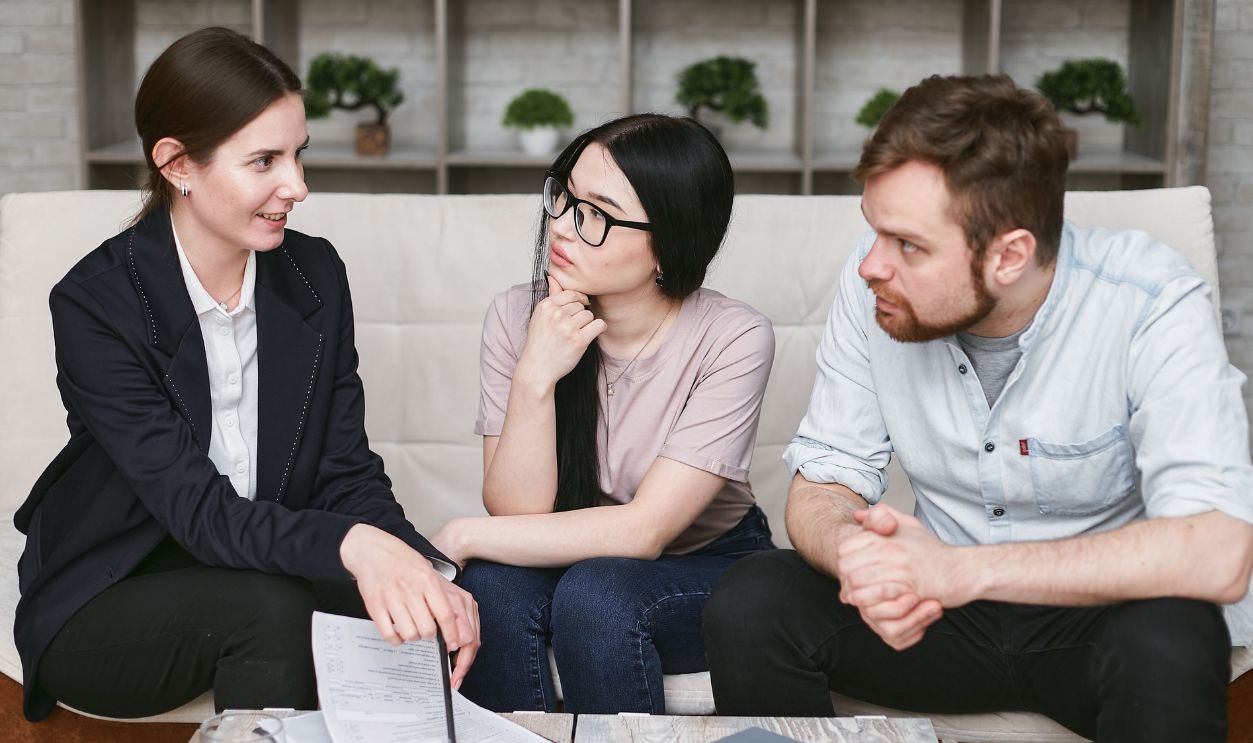 Three adults discussing business inside, focused on cooperation and strategy