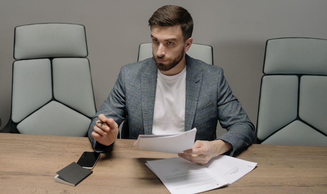 Professional businessman in a suit holding documents during a meeting in an office