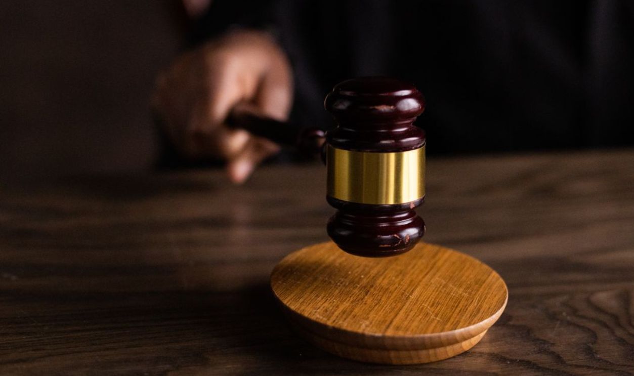 A gavel striking a sound block, symbolizing justice and legal authority in a courtroom setting