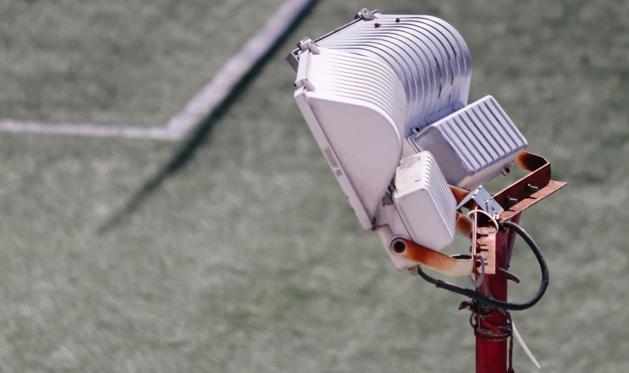 Close-up image of a floodlight on a sports field with white lines