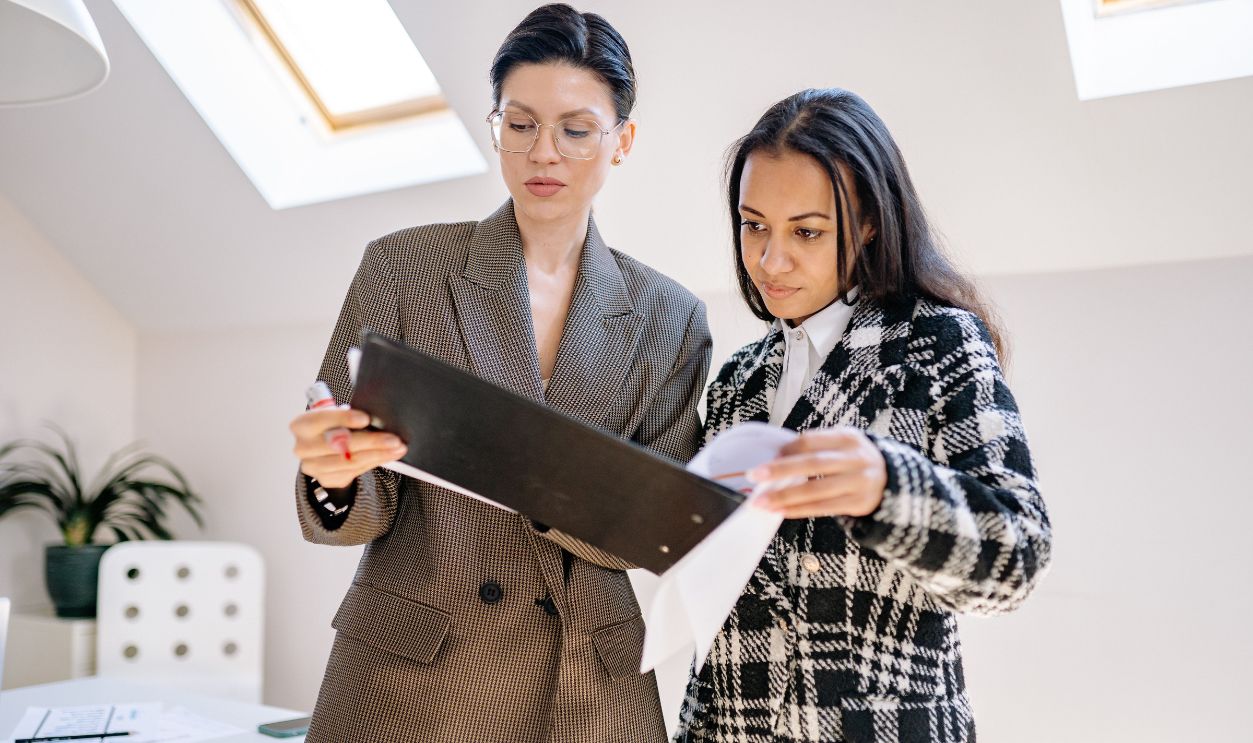 Two businesswomen reviewing documents in a modern office