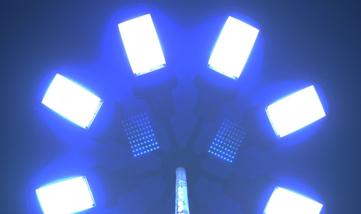 Close-up of bright street lamp lights forming a circular pattern in the night sky