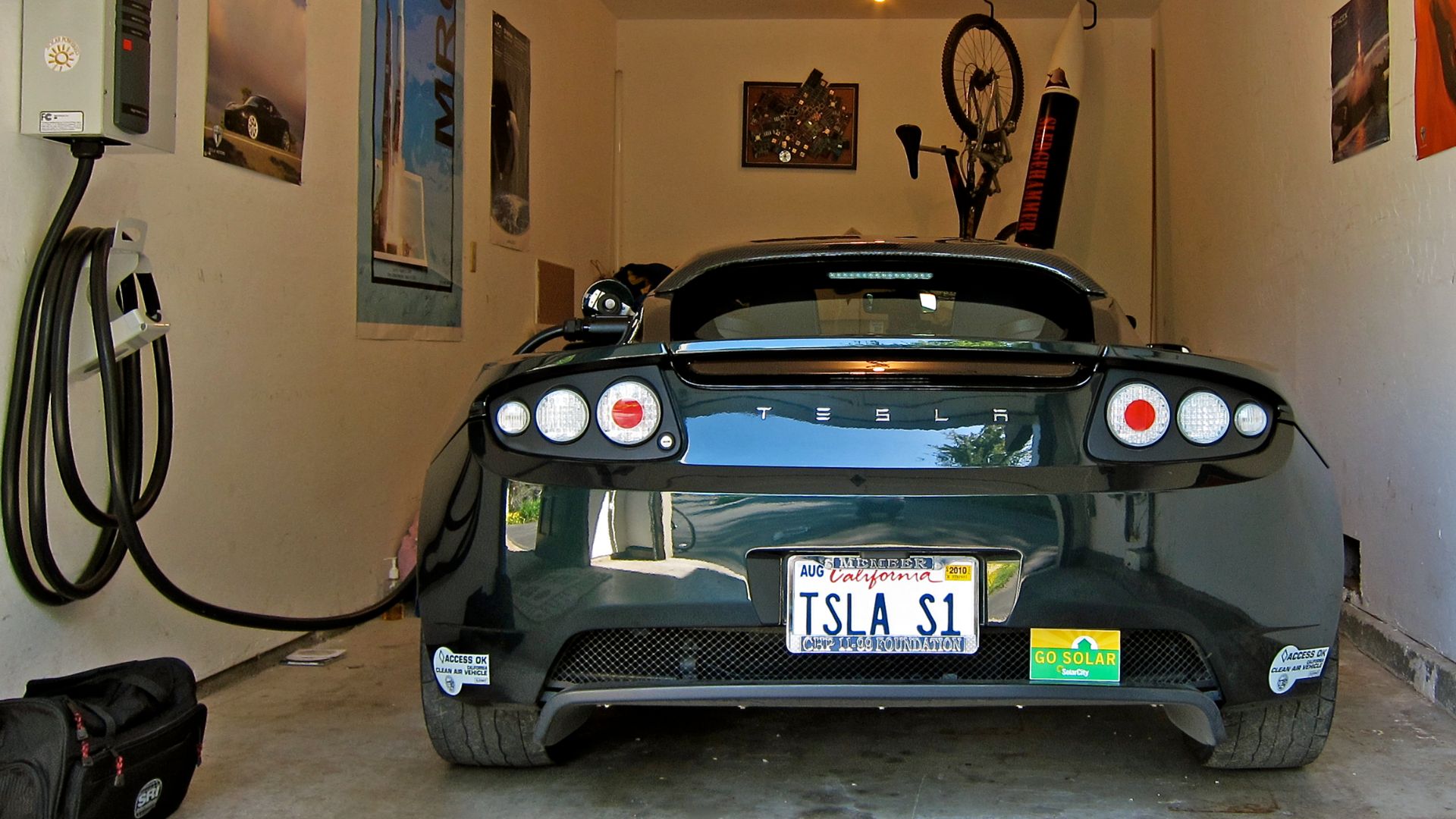 Tesla Roadster charging. Note the California Clean Air stickers that allow the EV free access to HOV lanes with solo driver.