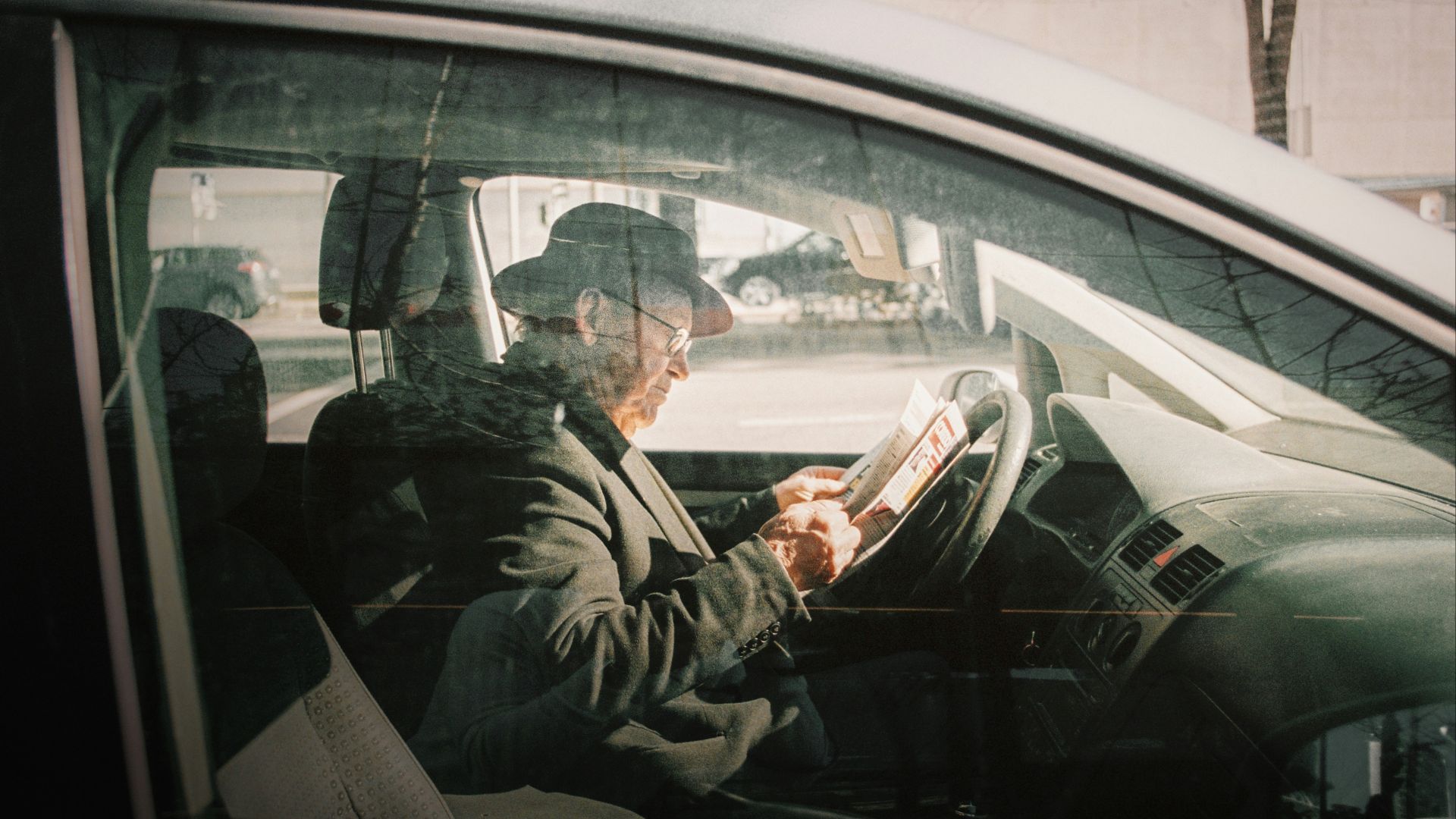 man in black jacket driving car