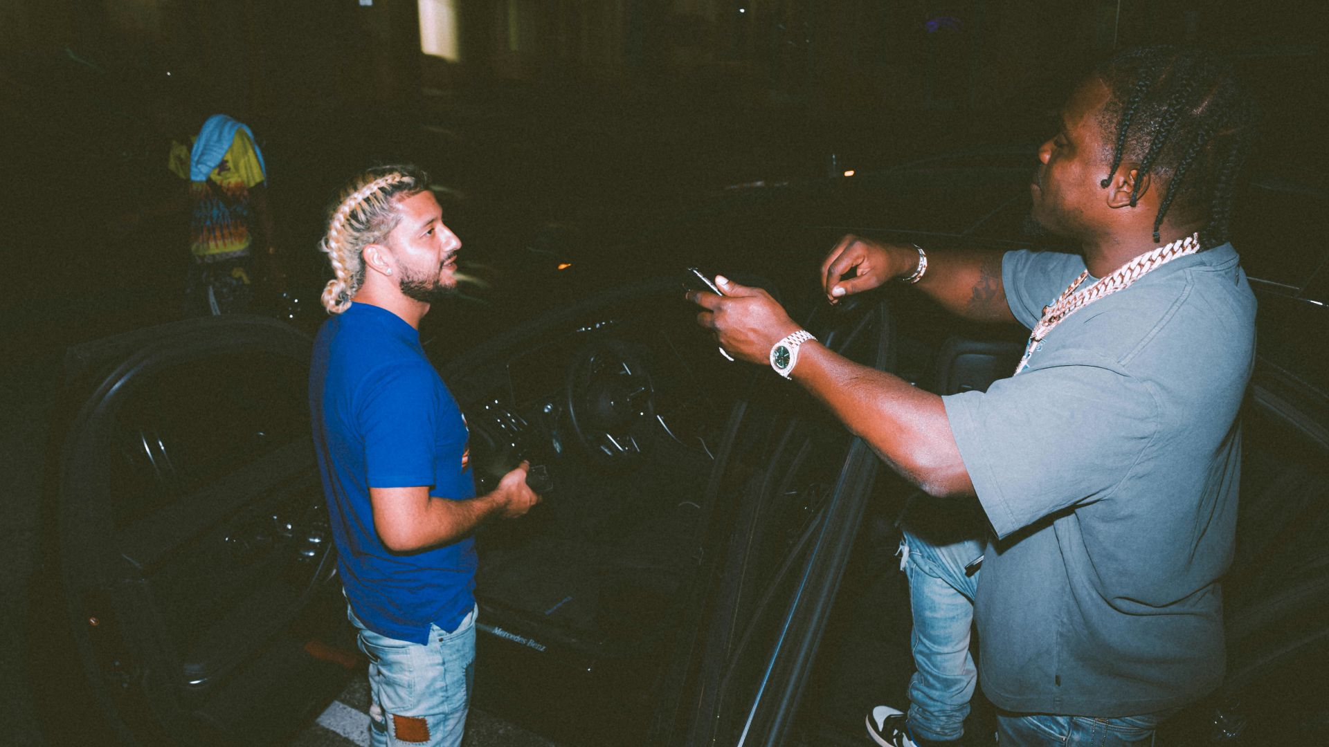 a man standing next to another man in a parking lot
