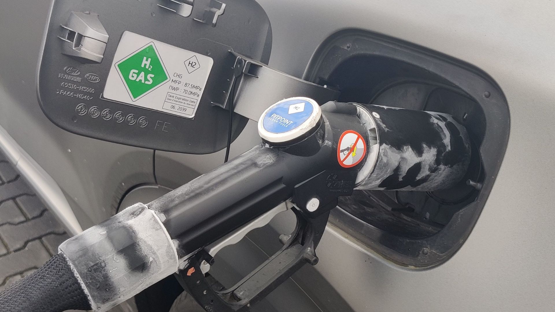 The refueling of a Hydrogen-powered vehicle. The vehicle is a Hyundai Nexo.
Note the condensation around the handle; this is because of the hydrogen gas expanding causing the handle to freeze.