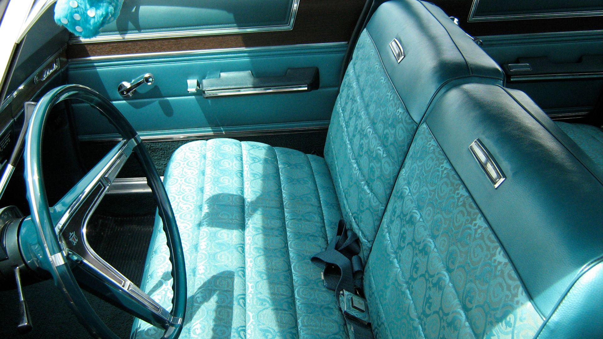 1967 Ambassador 990 four-door sedan by American Motors Corporation (AMC). This car is finished in two-tone aqua paint (Alameda Aqua #P34 primary color and Marina Aqua Metallic #P8 on the roof) with a matching standard interior upholstery and bench seats.