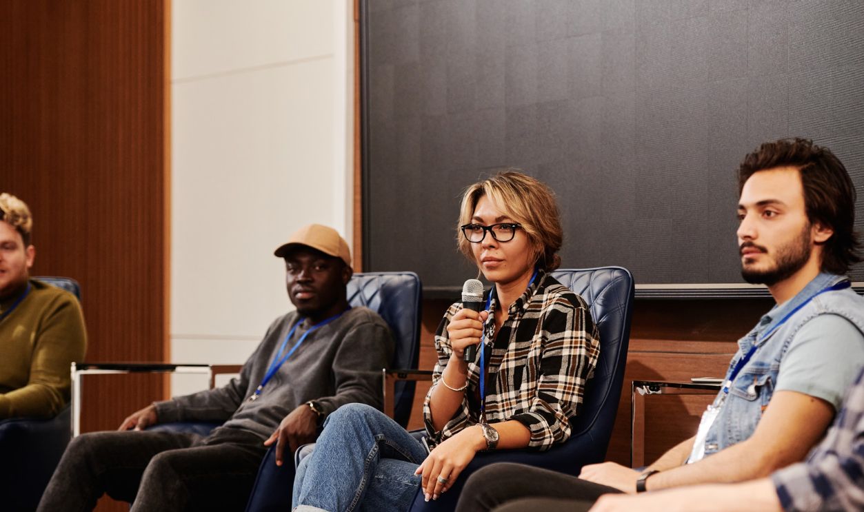 A diverse group of individuals engaged in an informative panel discussion at an indoor event