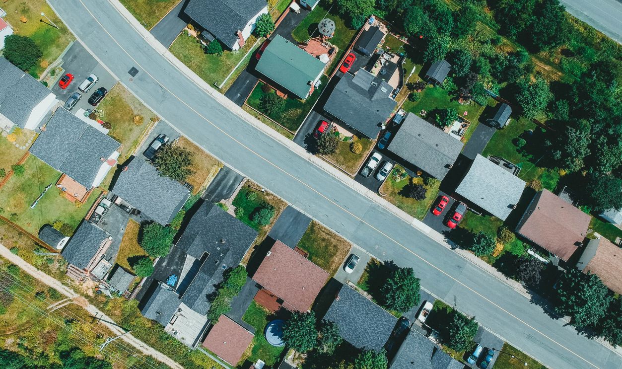 Aerial drone shot capturing suburban neighborhood houses and streets with greenery