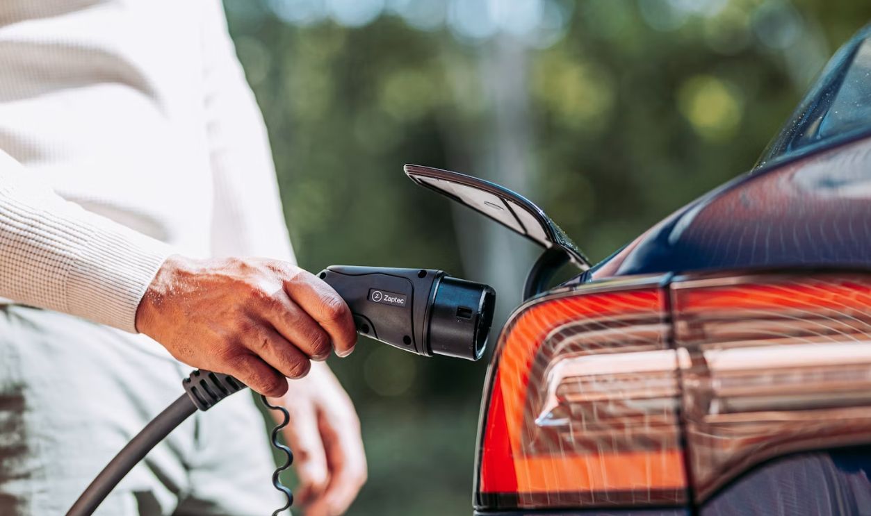 A man pumping gas into his car at a gas station