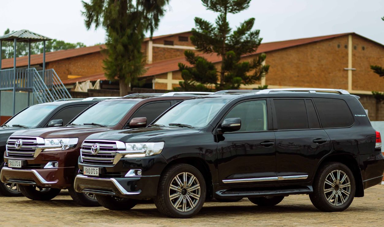 Three Toyota Land Cruiser SUVs parked outdoors on a sunny day