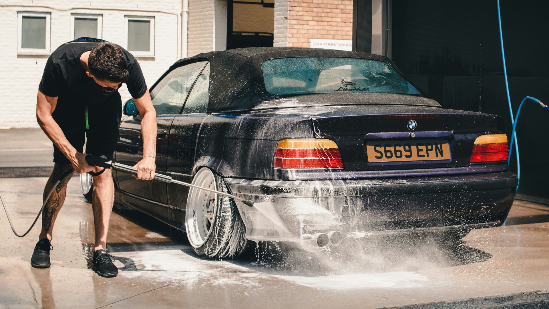 man washing BMW coupe