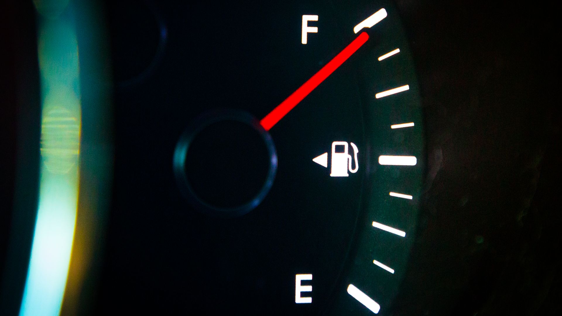 A car dashboard fuel gauge showing a full gas tank.