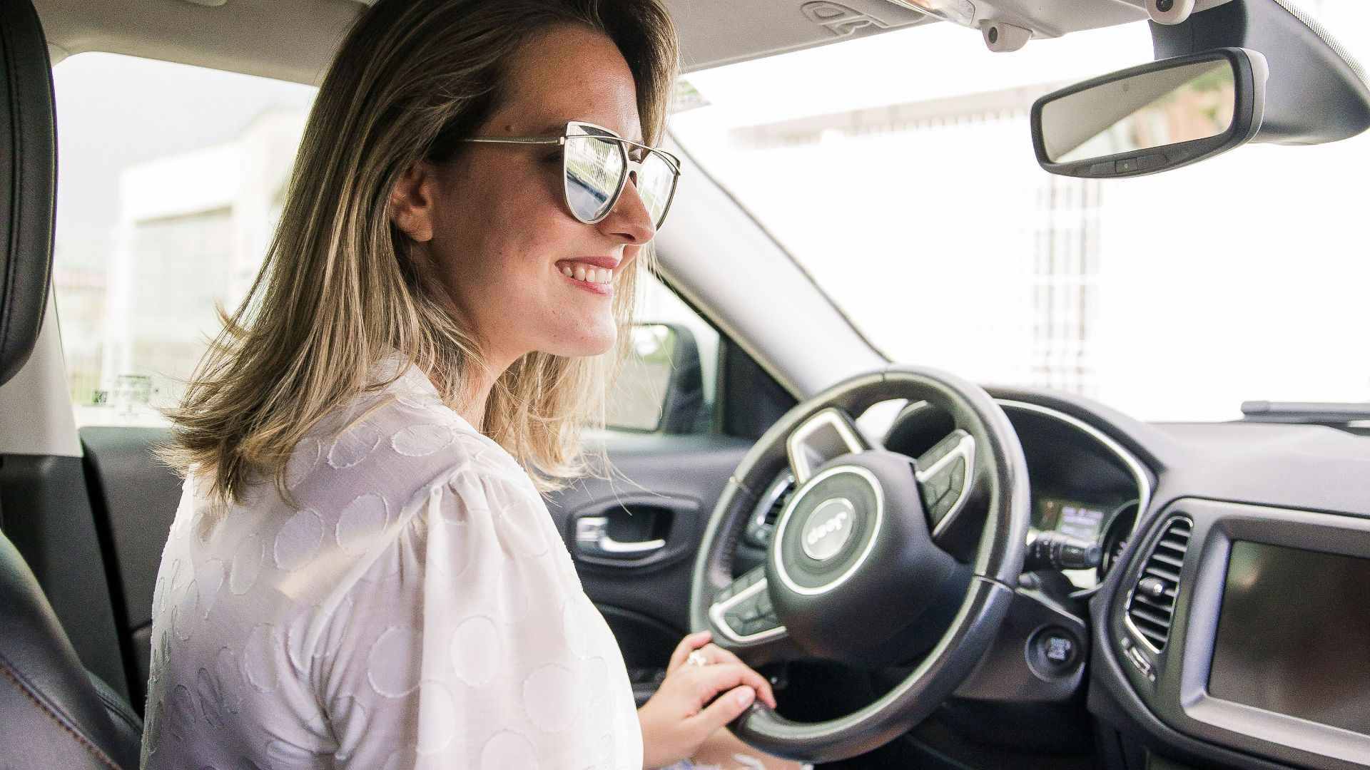 woman in white long sleeve shirt driving car