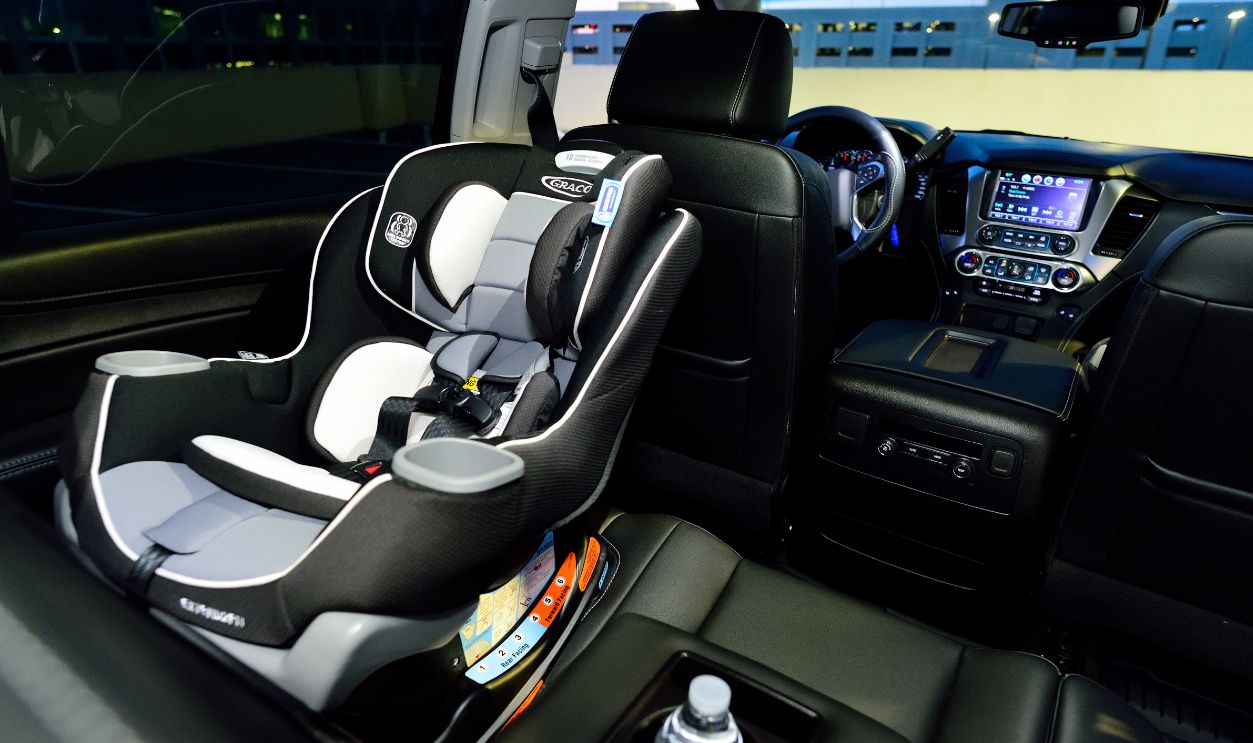 Interior of a car featuring a child safety seat and illuminated dashboard, captured at night