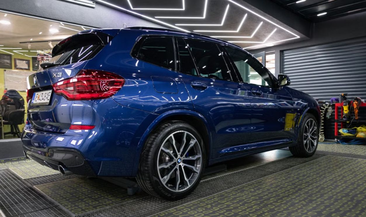 A shiny blue SUV showcased in a sleek modern car dealership, highlighting its design under bright interior lighting