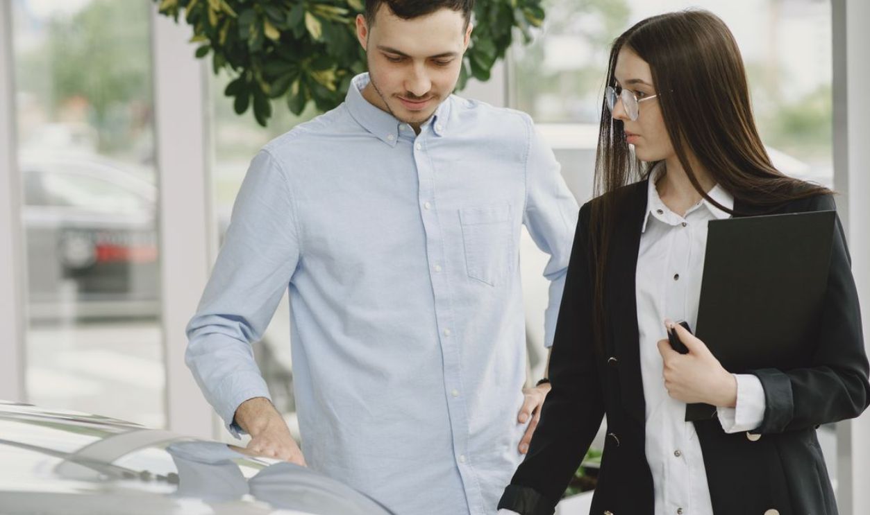 Professional interaction between a client and salesperson in a car dealership setting