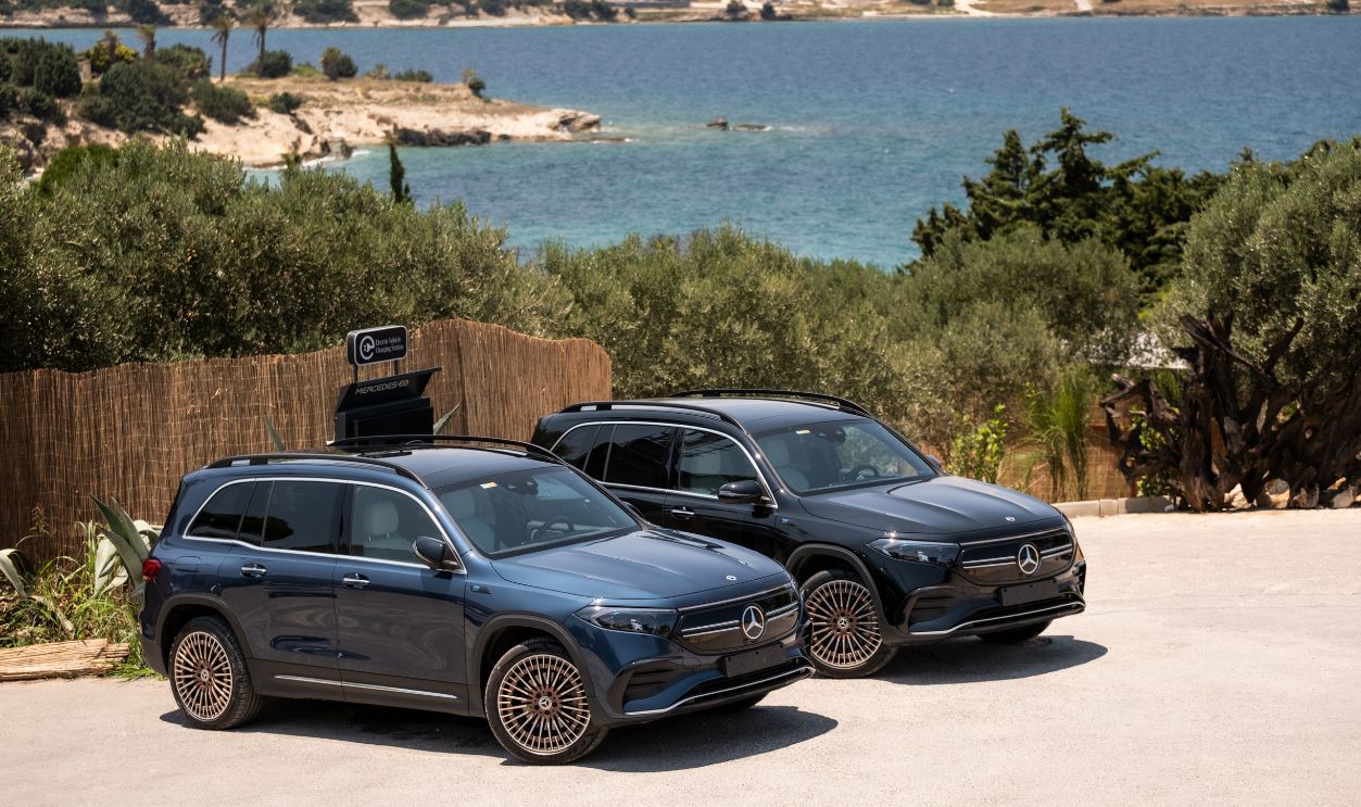 Two Mercedes EQB SUVs parked by the sunlit coast in Izmir, Turkiye