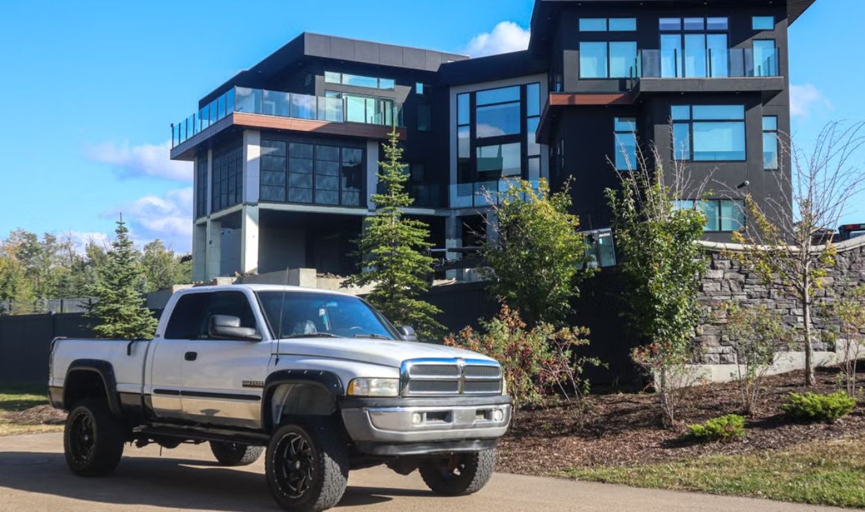 Stylish modern home with a parked silver pickup truck outdoors under a clear blue sky