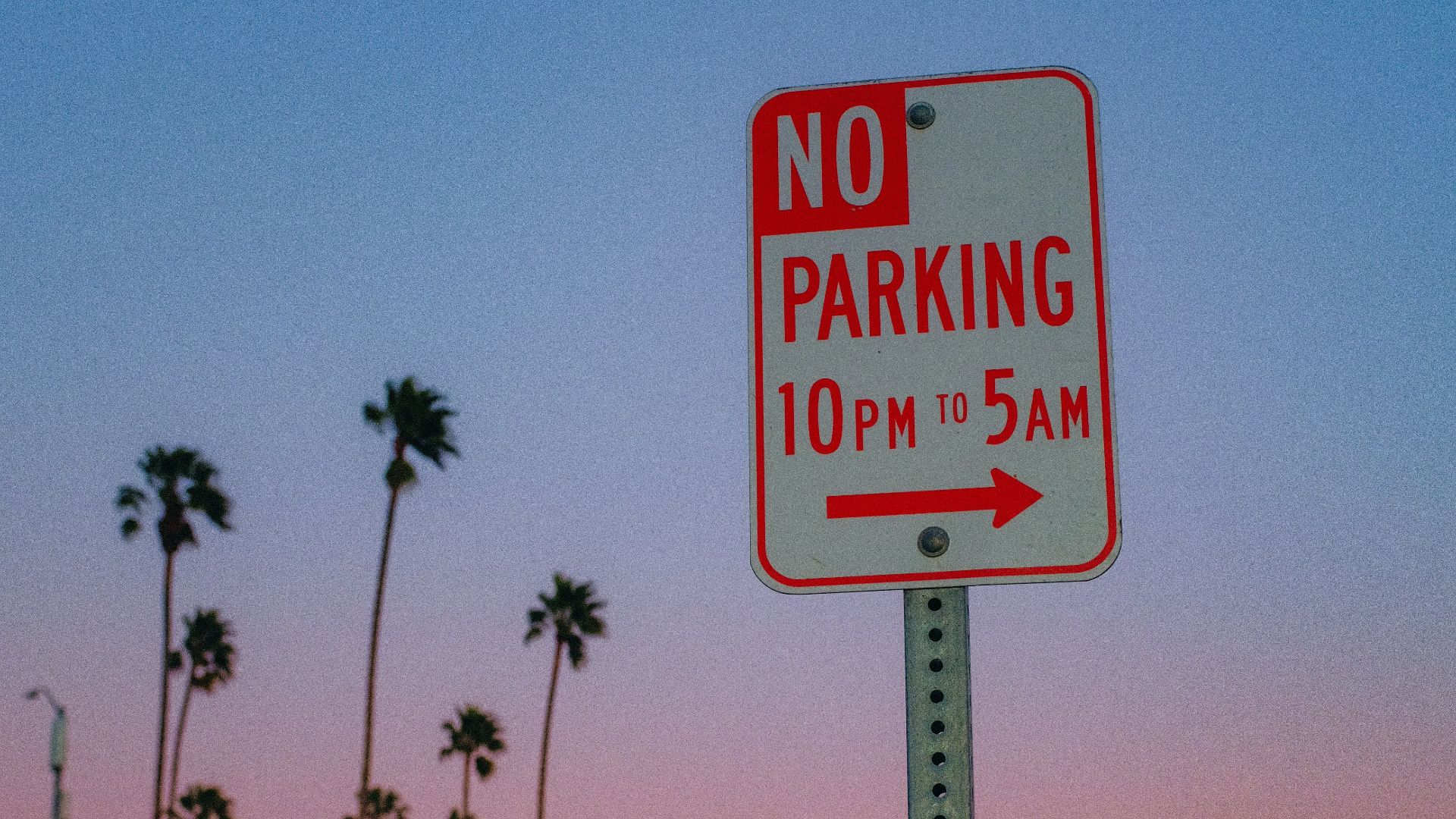 a no parking sign on the side of a road