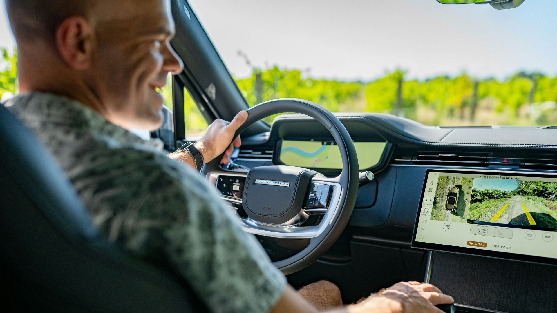 Man driving a modern car through a vineyard