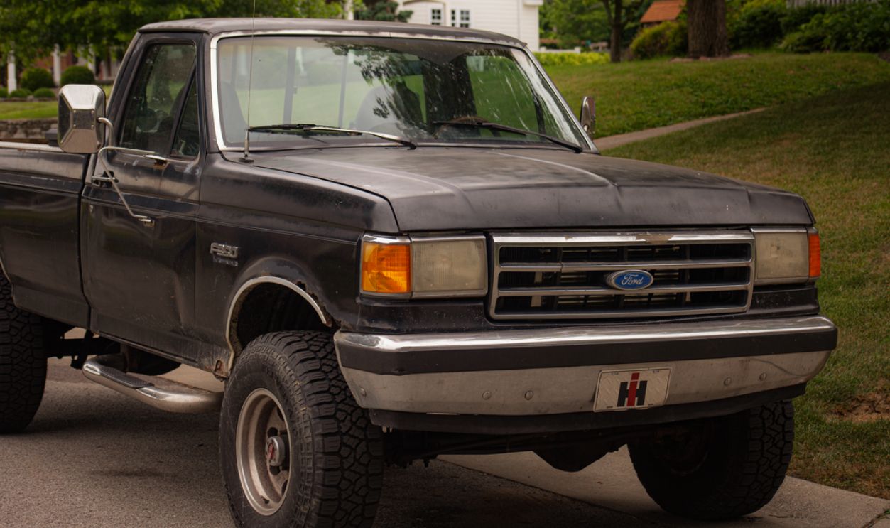 Vintage Ford pickup truck parked on a tree-lined suburban street showcasing automotive nostalgia