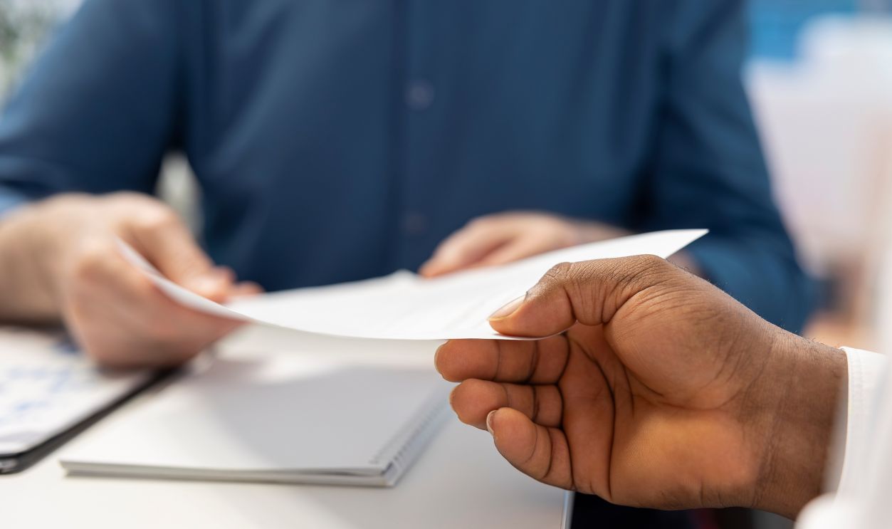 Senior man receiving the financial contract with retirement plan option, agreement to secure their pension and life savings for the future. Expert giving the document to his clients. Close up.