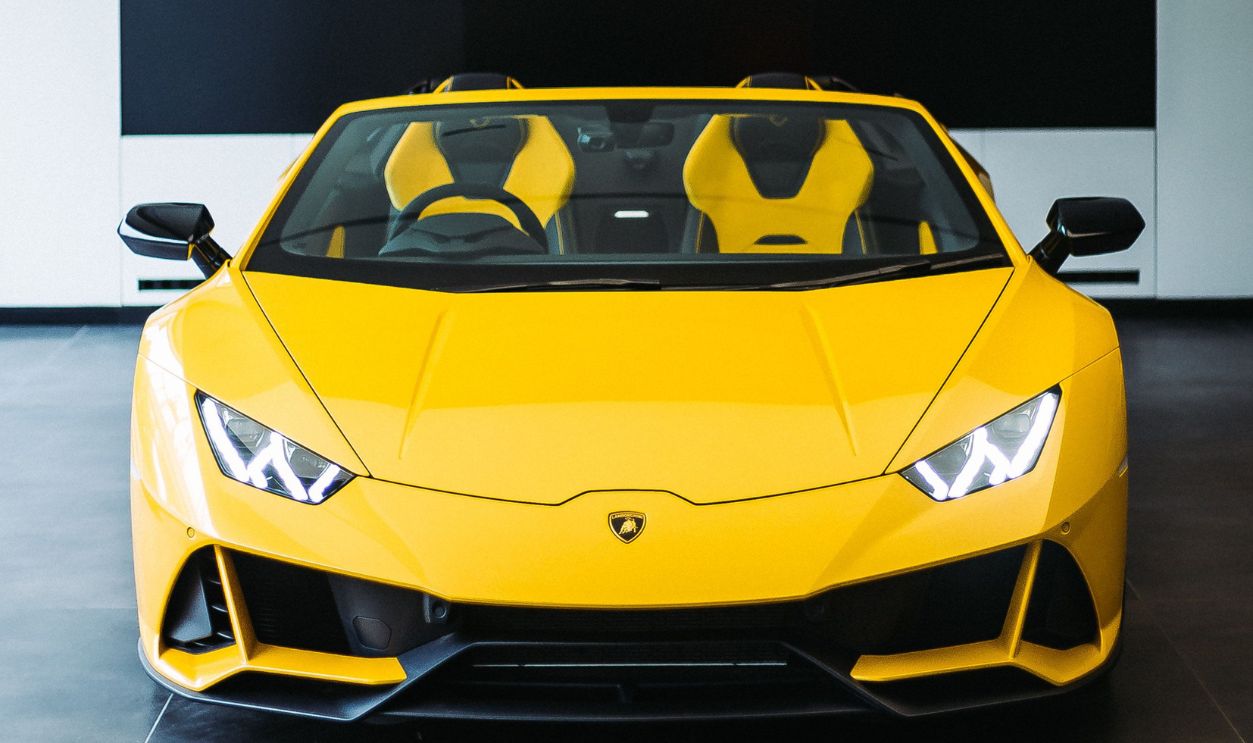 A striking yellow sports car parked in a modern indoor garage, showcasing elegance and style