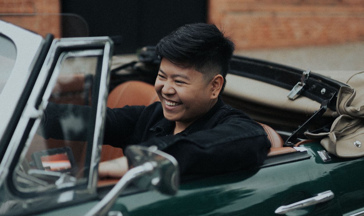 Smiling Asian man driving a classic cabriolet