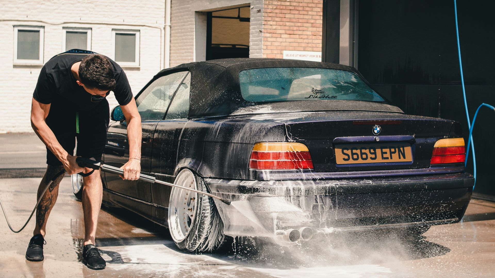 man washing BMW coupe