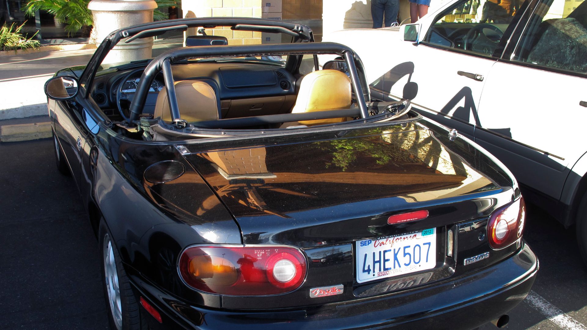 Una Mazda MX5 cabrio nera con rollbar