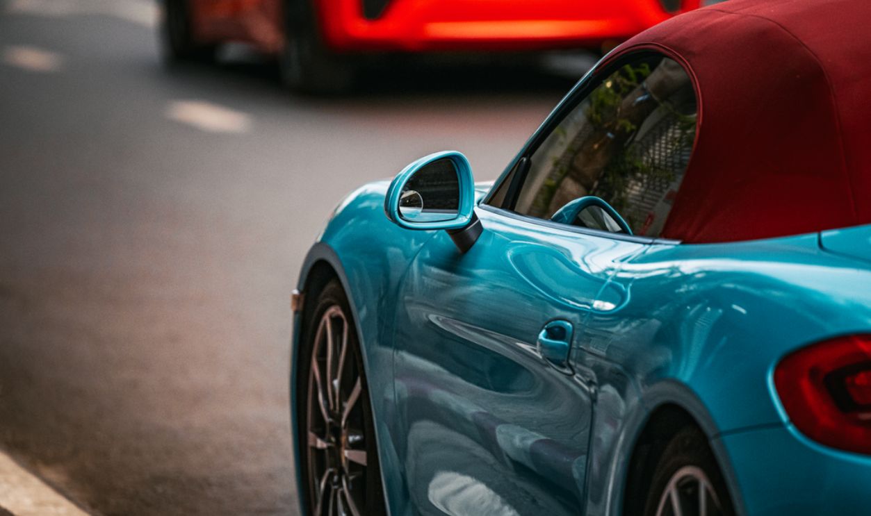 Vibrant blue sports car parked on a street in Bangkok, showcasing sleek design and urban charm
