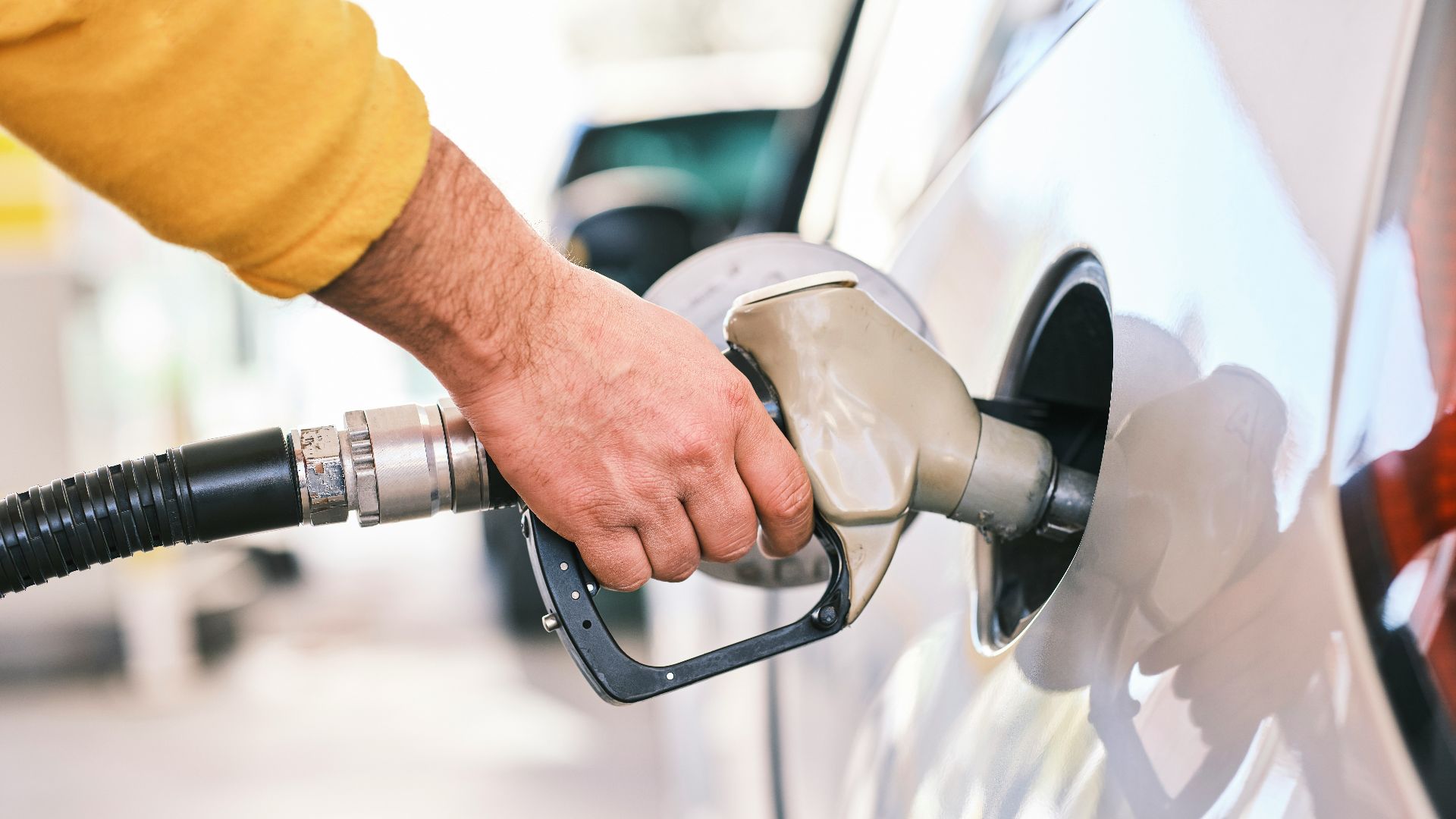 a man pumping gas into his car at a gas station