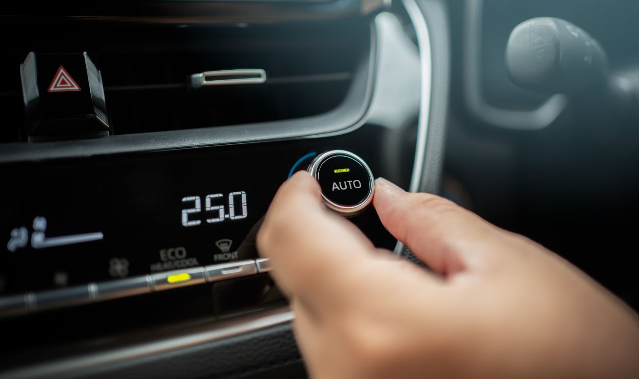 Driver adjusting car air conditioner system at interior panel. Car control panel showing temperature and human fingers turning button hot and cool for comfortable.