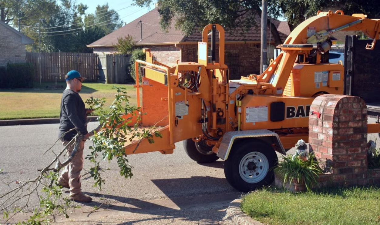 /worker-operating-wood-chipper-in-suburban-setting