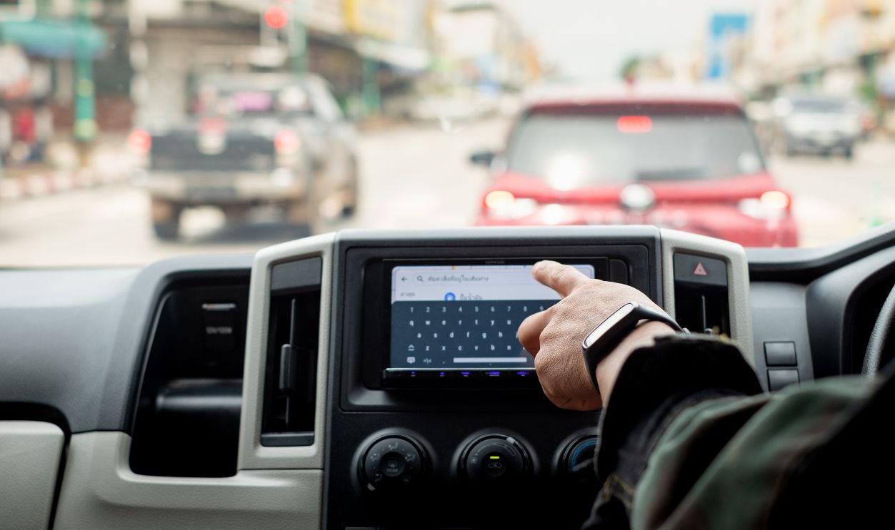 Driver's Hand Using GPS Screen or map During Road Trip, Dangers Of Using Technology While Driving